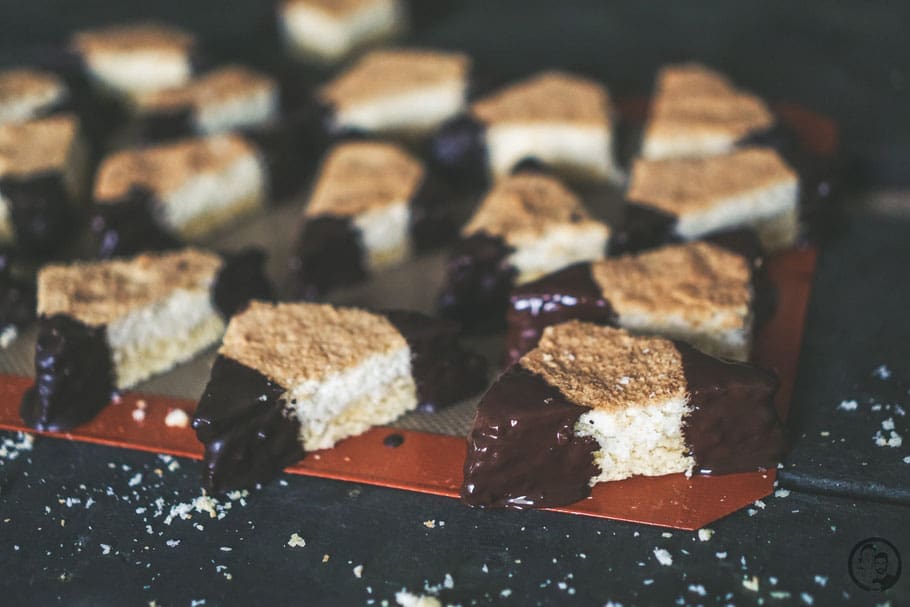 kokosecken | Da Torsten Geburtstag hatte, haben wir letztes Wochenende für seine Kollegen einige Leckereien zubereitet. Ich glaube, da freuen die sich das ganze Jahr drauf und es wurden auch direkt ein paar Wünsche geäußert. Unsere Pizzaschnecken durften auf keinen Fall fehlen, Hackbällchen wurden auch geordert und außerdem die berühmte Donauwelle nach dem Rezept von meiner Mutter. Aber wir lassen es uns dann ja auch nicht nehmen, ebenfalls etwas noch Unbekanntes mitzubringen! Also kamen diese super leckeren Kokosecken mit hinzu und die waren der Hit im Büro.