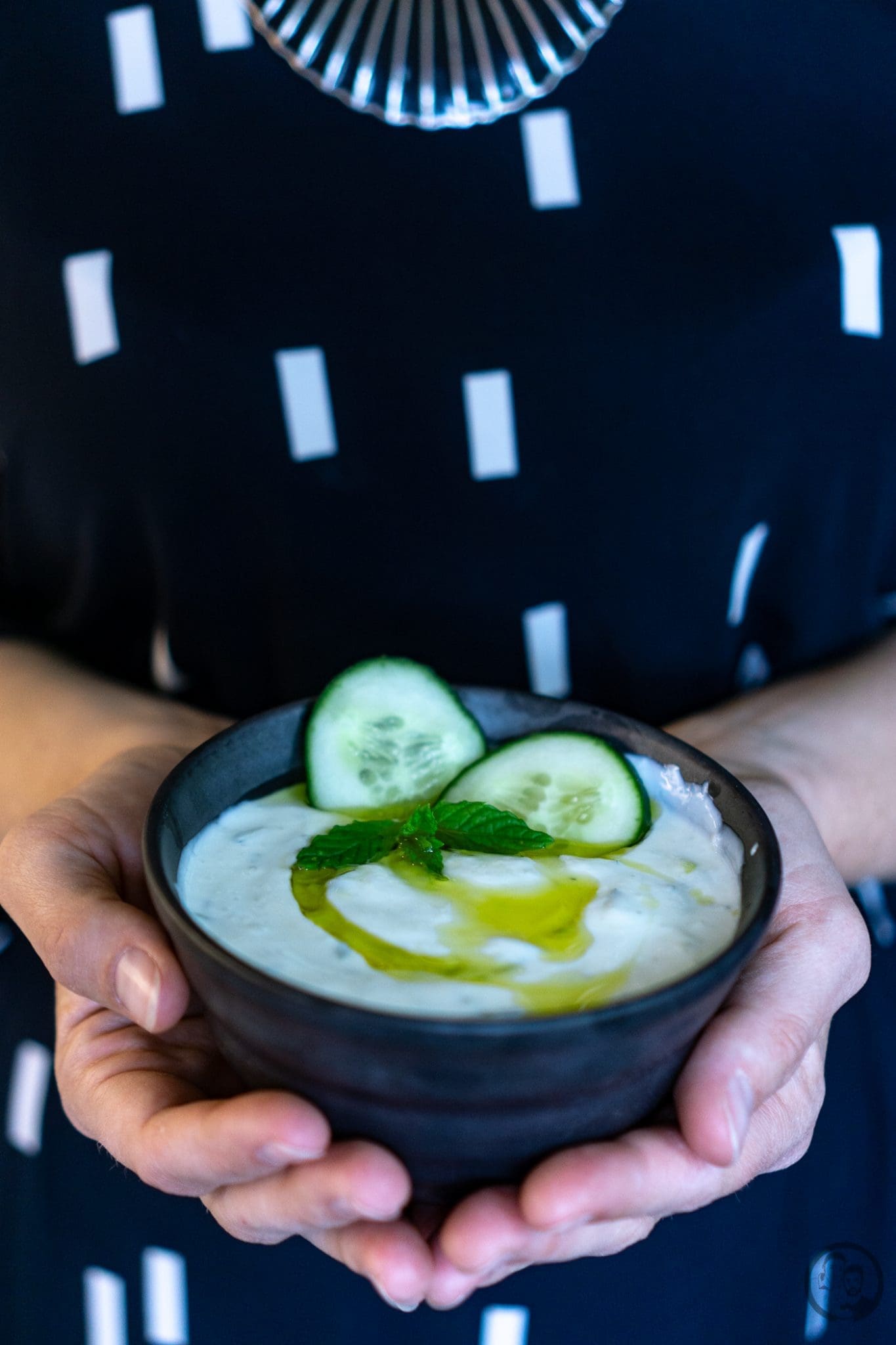 Schale mit Tzatziki in Händen