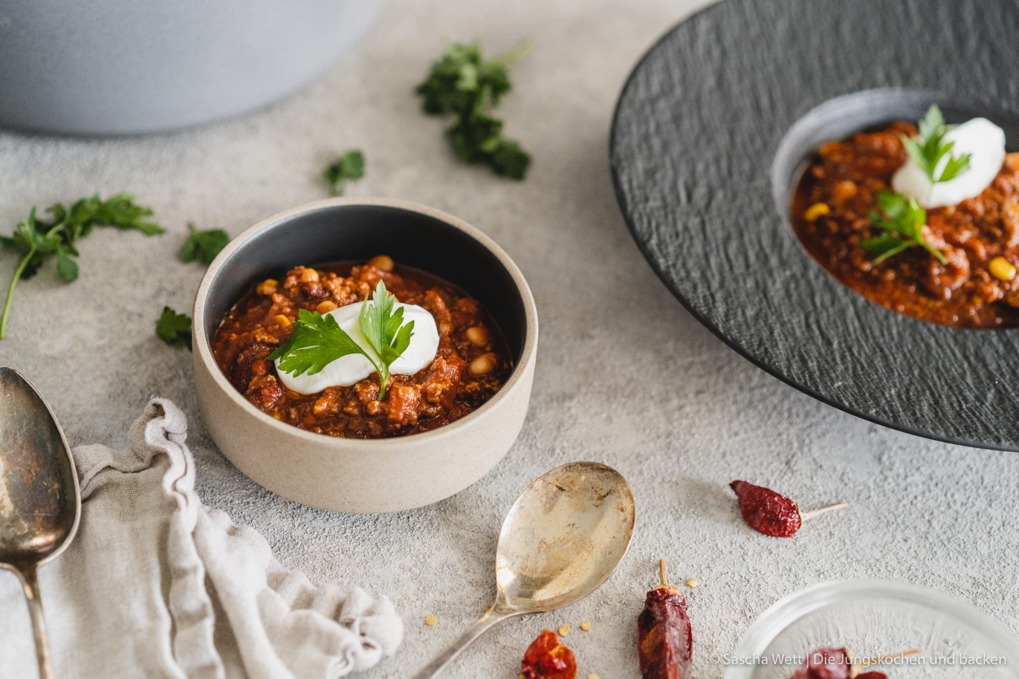 Chili Con Carne 3 | Torsten und ich haben Anfang des Monats unsere Geburtstage nachgefeiert. Da wir aber nur ein paar Tage vorher aus dem Urlaub zurückgekommen sind, war nicht wirklich viel Zeit für riesige Vorbereitungen. Daher haben wir auf einen Partyfood-Klassiker schlechthin zurückgegriffen - ein leckeres Chili con carne! Denn ein geniales Chili lässt sich in riesigen Mengen und mit super wenig Vorbereitung zubereiten - eigentlich macht es sich fast von alleine. Trotzdem hat wahrscheinlich jeder ein etwas anderes Rezept für sein Chili con carne zur Hand. In unsere Version kommen 1-2, für unsere Freunde, unwahrscheinlichen Zutaten, aber genau die machen es aus.