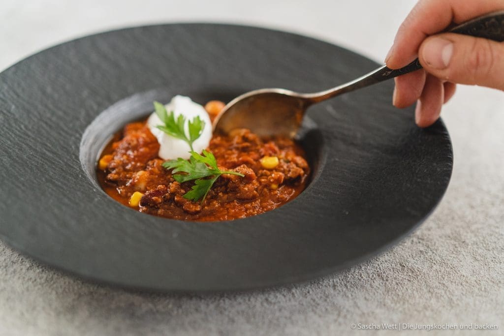 Chili Con Carne 7 | Torsten und ich haben Anfang des Monats unsere Geburtstage nachgefeiert. Da wir aber nur ein paar Tage vorher aus dem Urlaub zurückgekommen sind, war nicht wirklich viel Zeit für riesige Vorbereitungen. Daher haben wir auf einen Partyfood-Klassiker schlechthin zurückgegriffen - ein leckeres Chili con carne! Denn ein geniales Chili lässt sich in riesigen Mengen und mit super wenig Vorbereitung zubereiten - eigentlich macht es sich fast von alleine. Trotzdem hat wahrscheinlich jeder ein etwas anderes Rezept für sein Chili con carne zur Hand. In unsere Version kommen 1-2, für unsere Freunde, unwahrscheinlichen Zutaten, aber genau die machen es aus.