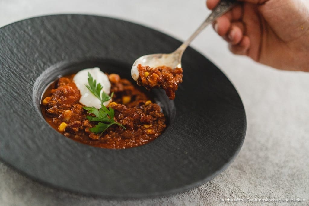 Chili Con Carne 8 | Torsten und ich haben Anfang des Monats unsere Geburtstage nachgefeiert. Da wir aber nur ein paar Tage vorher aus dem Urlaub zurückgekommen sind, war nicht wirklich viel Zeit für riesige Vorbereitungen. Daher haben wir auf einen Partyfood-Klassiker schlechthin zurückgegriffen - ein leckeres Chili con carne! Denn ein geniales Chili lässt sich in riesigen Mengen und mit super wenig Vorbereitung zubereiten - eigentlich macht es sich fast von alleine. Trotzdem hat wahrscheinlich jeder ein etwas anderes Rezept für sein Chili con carne zur Hand. In unsere Version kommen 1-2, für unsere Freunde, unwahrscheinlichen Zutaten, aber genau die machen es aus.