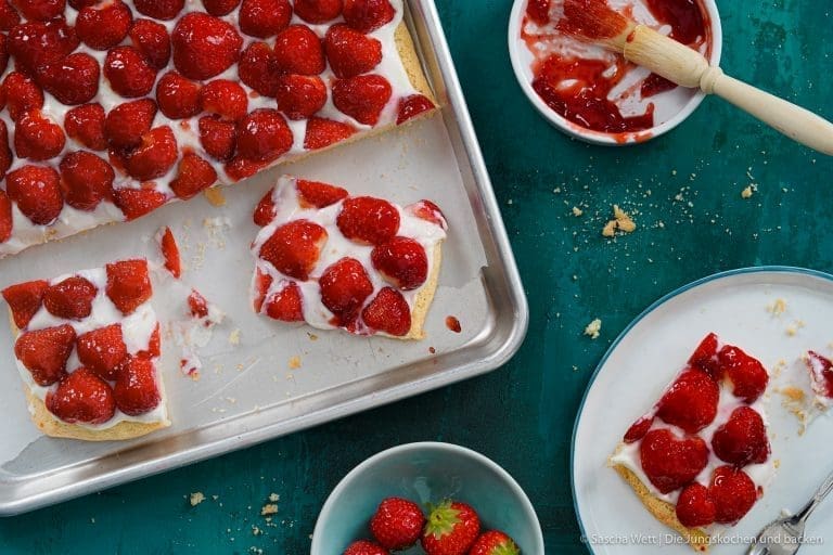 Erdbeer Blechkuchen 1 | Manche Rezepte schmecken nach Zuhause. Bei uns sind das die von Oma Lore – aufgeschrieben an einem Küchentisch im Oberberg, weitergegeben über Generationen und inzwischen unzählige Male von uns nachgekocht. Hühnersuppe, wenn die Nase läuft. Rinderrouladen am Sonntag. Nusskuchen, einfach weil.