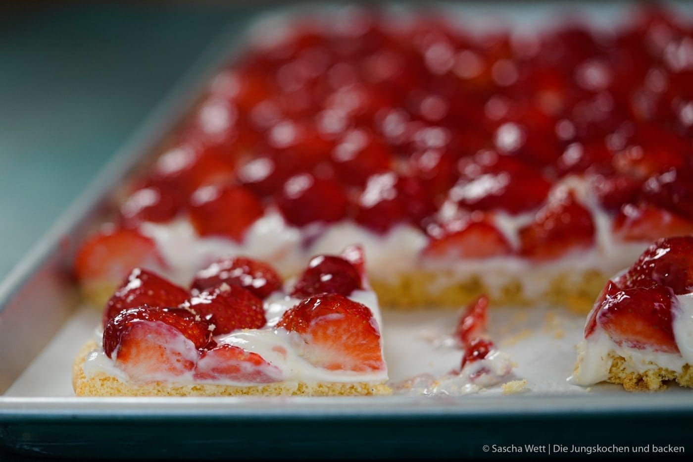 Erdbeer Blechkuchen 6 | Es gibt 2 Früchte, die zur selben Zeit Saison haben, die wir beide super gerne verarbeiten und essen und die auch noch perfekt zusammen passen. Heute ist es zwar nicht der Rhabarber, den wir auf dem Schirm haben, sondern die Erdbeere. Findet ihr nicht auch, dass diese Zeit des Jahres einfach die allerbeste ist, weil ein Erdbeerkuchen oder auch ein Rhabarberkuchen sowas von erfrischend ist, dass man fast jede andere Frucht einfach stehen lassen könnte?! Und dabei gibt es auch noch Millionen Möglichkeiten, die leckeren Früchte zu verarbeiten - da sind der Fantasie keine Grenzen gesetzt.