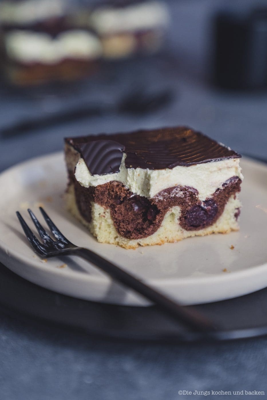 Donauwelle 2020 6 | Bei mir zu Hause heißt dieser Kuchen einfach „Monis Donauwelle“ nach meiner Mama. Der kommt immer auf den Geburtstagstisch ... saftig, süß, mit Schattenmorellen, Vanille-Puddingcreme und Schokoguss mit diesen markanten Wellen. Klingt nach ganz viel Aufwand? Keine Sorge mit etwas Planung und den richtigen Kniffen gelingt der Klassiker total entspannt. Ich verrate dir, wie du Pudding und Butter schön langsam vereinst, damit die Creme nicht gerinnt, und wie du den Schokoguss wackelig-dekorativ hinbekommst. Mehr Familienliebe auf dem Blech geht nicht.