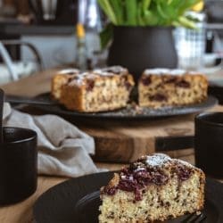 Versunkener Kirschkuchen auf dem Tisch. Angeschnitten im Vordergrund