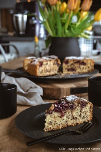 Versunkener Kirschkuchen auf dem Tisch. Angeschnitten im Vordergrund