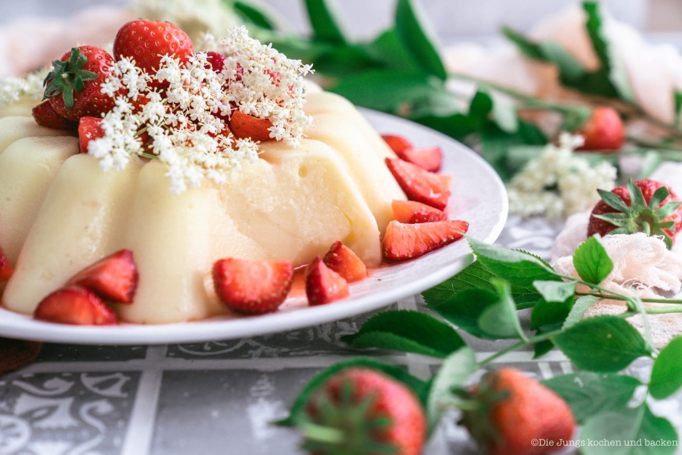 Rezept für gestürzten Holunderblütenpudding mit Erdbeeren. Ein tolles Dessert, das auch noch ein Hingucker ist! Der Pudding lässt sich easy vorbereiten und ist schnell gemacht. #holunderblütensirup #dessert #rezepte