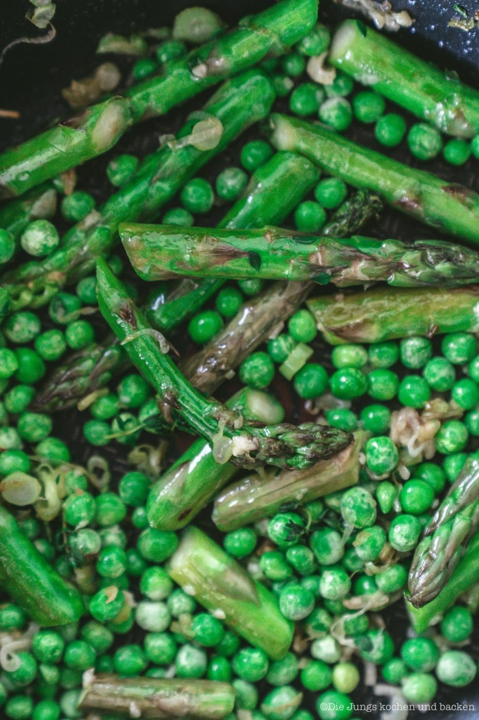 Grüner Spargel und Erbsen braten in der Pfanne