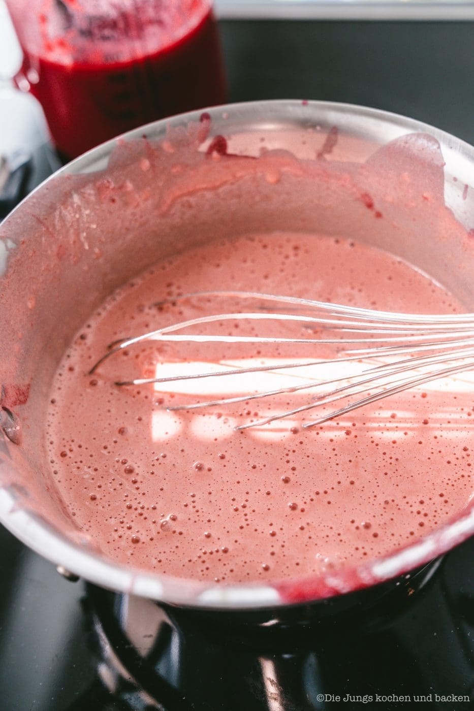 Johannisbeer Curd wird im Topf mit dem Schneebesen gerührt