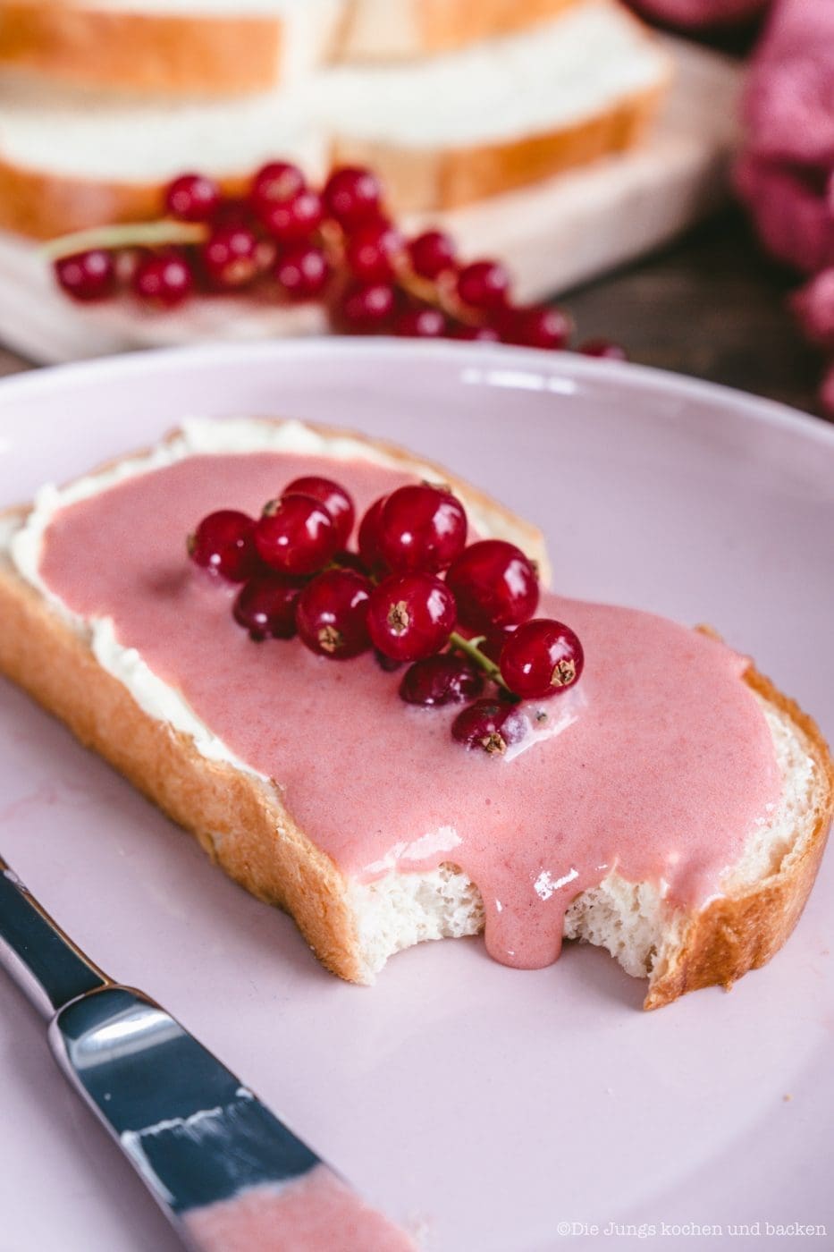 Angebissene Brotscheibe mit fruchtigem Johannisbeer Curd