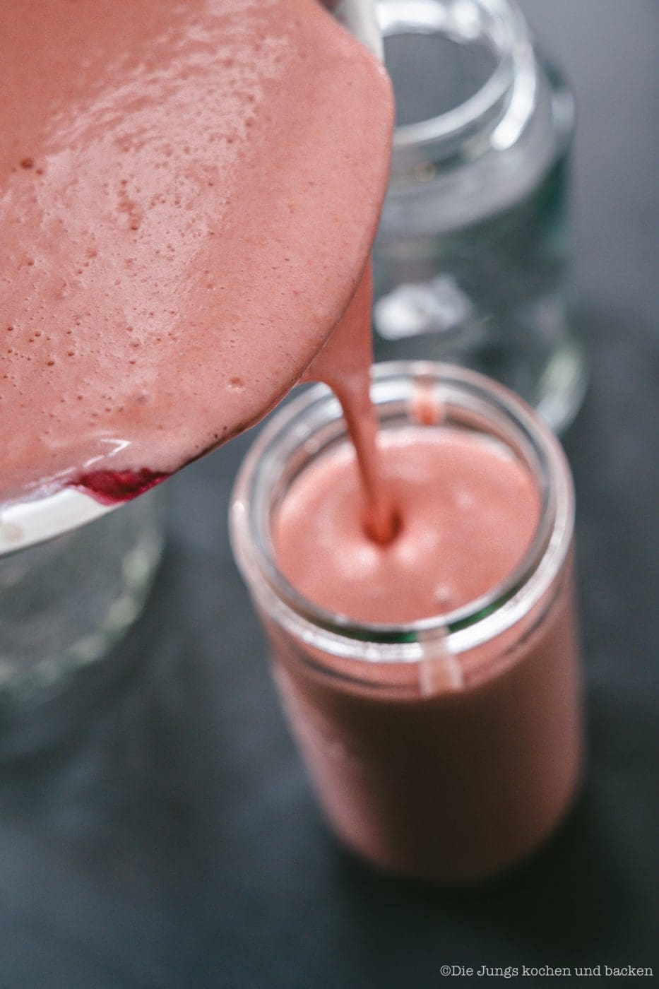 Frisch gekochtes Johannisbeer Curd wird in ein Glas gefüllt