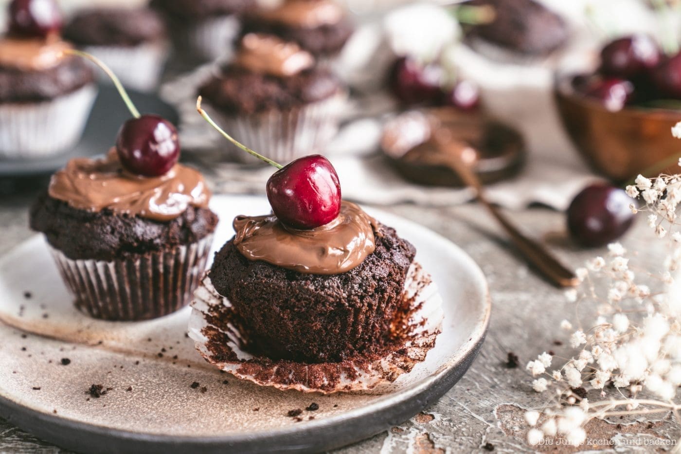 Kirsch Schokomuffin 1 | Heute begrüßen wir euch wieder zu einer wundervollen Blogparade!! Beim letzten mal drehte sich alles um Beeren, beim Berry Boom, und nun wird es höchste Zeit für den großen Auftritt der Kirsche. Ich, bzw. wir, lieben Kirschen über alles - als kleines Kind habe ich schon viel Zweit in Kirschbäumen verbracht und gemeinsam mit meinem Vater genascht bevor die roten Früchtchen überhaupt einen Eimer gesehen haben. Also wollte ich auch ein Rezept aus der Kindheit hervorholen und welches Kind steht nicht auf Schokomuffins mit Kirschen & Nuss-Nougat Creme - ok ok, ich glaube jeder Erwachsene auch!
