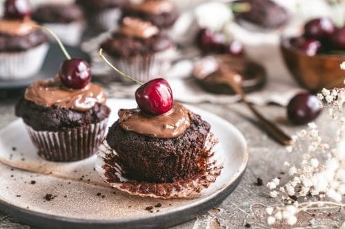 Schokomuffins mit Kirschen & Nuss-Nougatcreme 3 Kirsch Schokomuffin 1 | Heute begrüßen wir euch wieder zu einer wundervollen Blogparade!! Beim letzten mal drehte sich alles um Beeren, beim Berry Boom, und nun wird es höchste Zeit für den großen Auftritt der Kirsche. Ich, bzw. wir, lieben Kirschen über alles - als kleines Kind habe ich schon viel Zweit in Kirschbäumen verbracht und gemeinsam mit meinem Vater genascht bevor die roten Früchtchen überhaupt einen Eimer gesehen haben. Also wollte ich auch ein Rezept aus der Kindheit hervorholen und welches Kind steht nicht auf Schokomuffins mit Kirschen & Nuss-Nougat Creme - ok ok, ich glaube jeder Erwachsene auch!