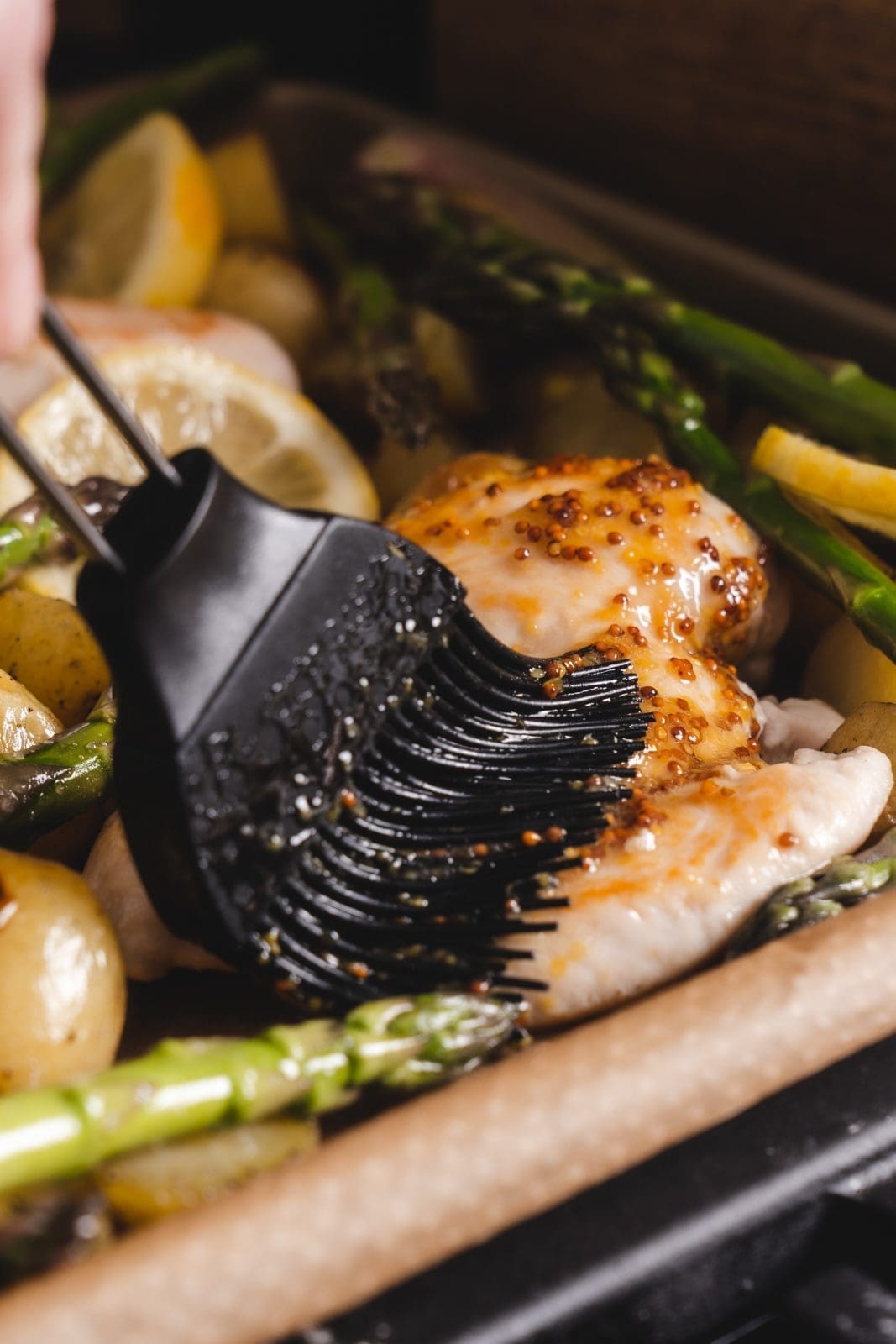 Honig-Senf-Hähnchen vom Blech  auf dem Blech beim finalen Marinieren vor dem Backen