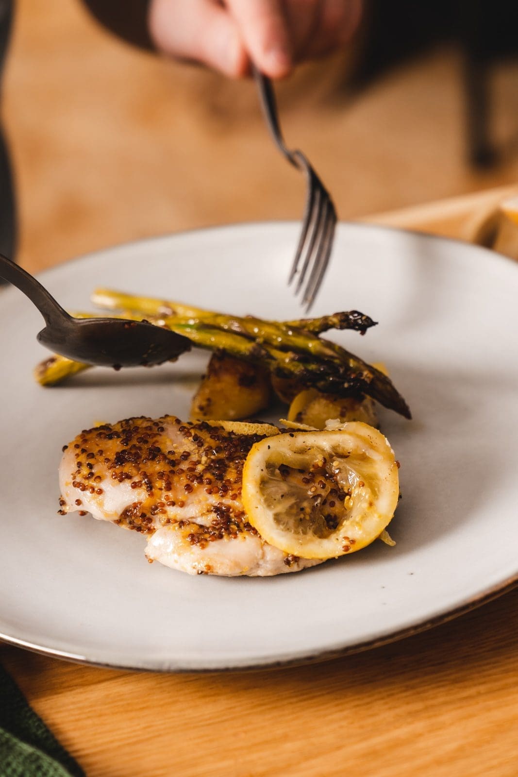 Teller vom Honig-Senf-Hähnchen vom Blech wird angerichtet