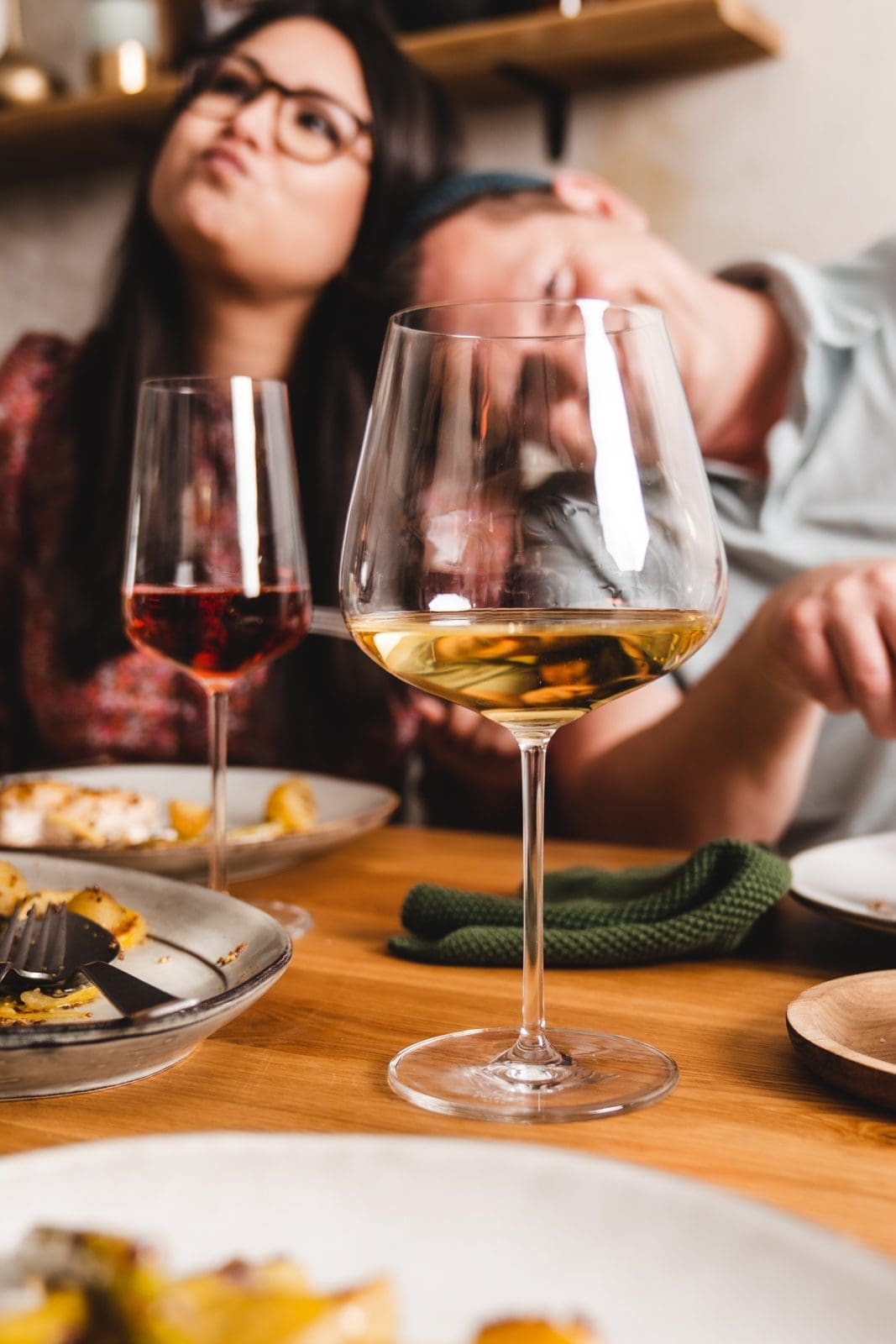 Michelle und Torsten glücklich und gesättigt mi Weingläsern vor sich