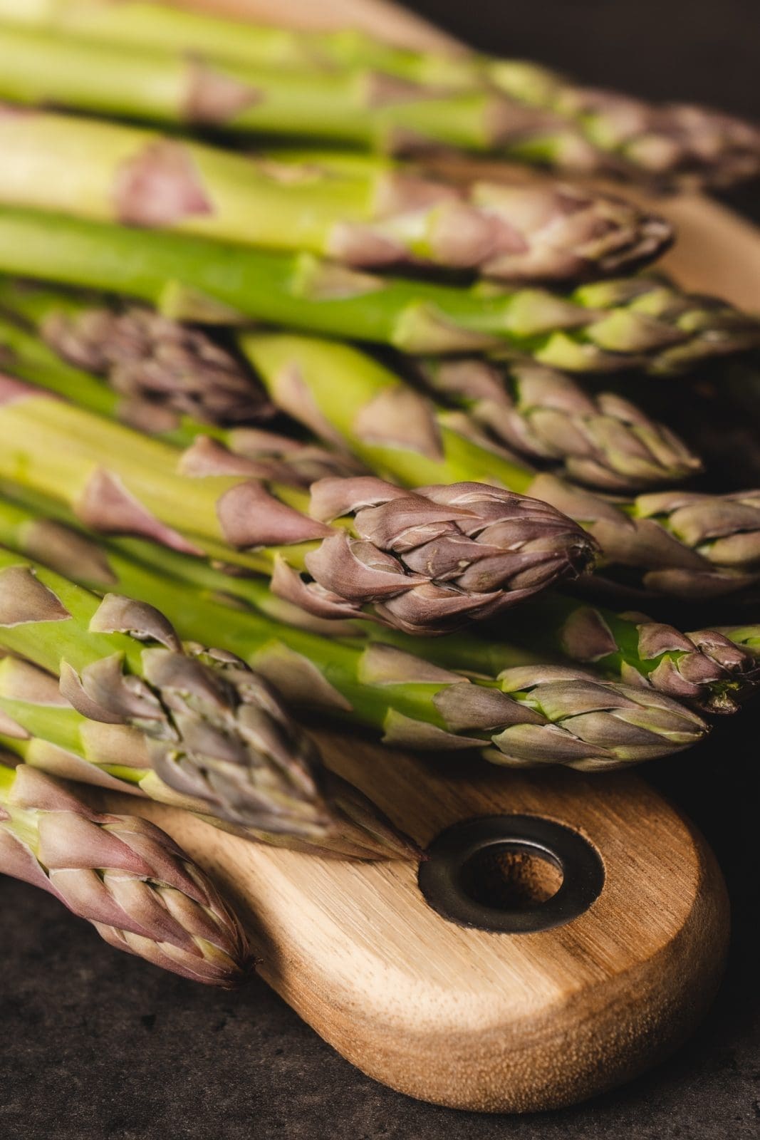 Frischer grüner Spargel auf Holzbrett