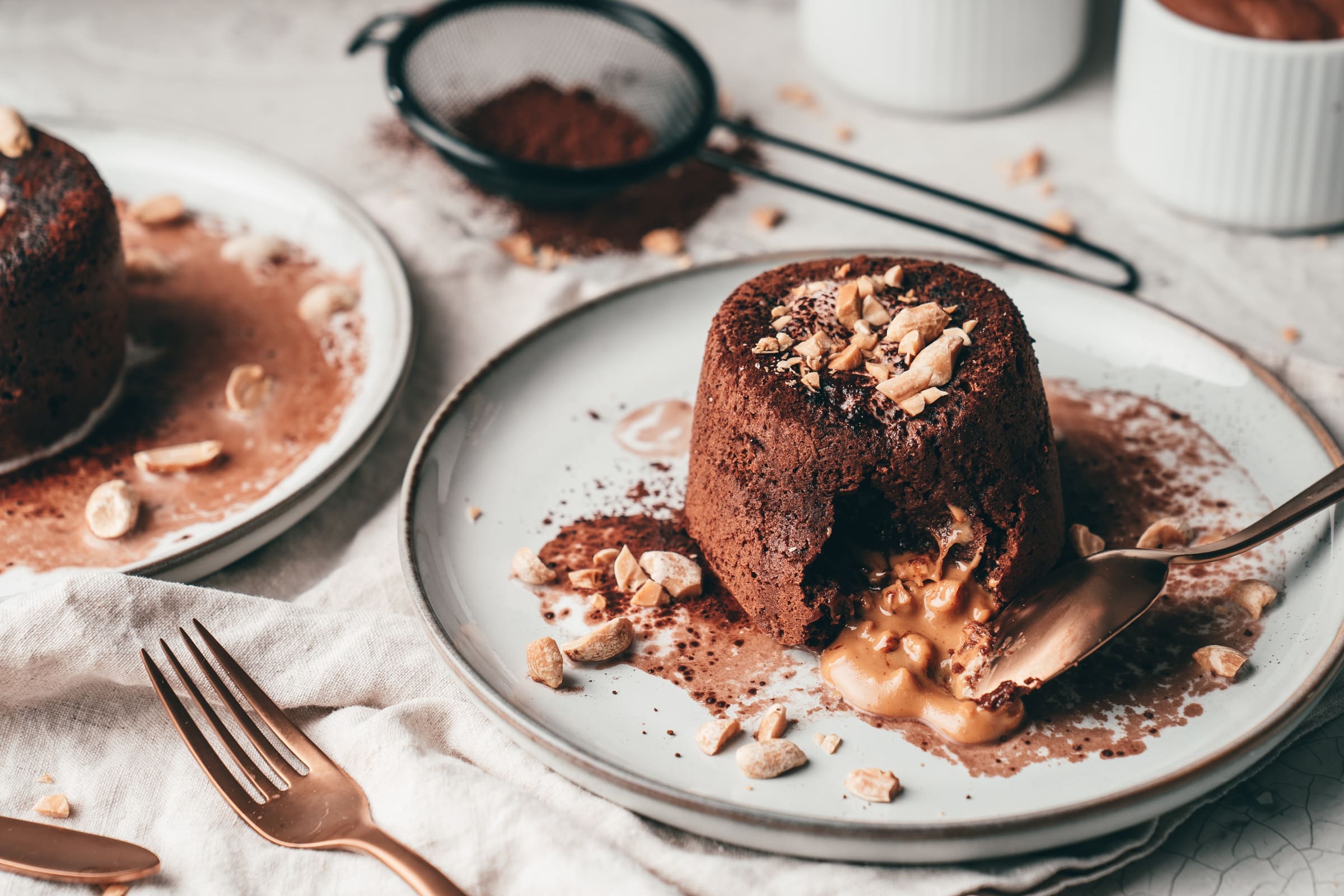 Melted Peanutbutter Cake 18 | Wie so oft in den letzten Wochen, spielte das Aprilwetter am vorletzten Wochenende mal wieder komplett verrückt. Morgens früh noch blendende Sonnenstrahlen, dann ein stockfinsterer Himmel und später dann Regen, Hagel und sogar Schnee. Ein richtiger Schietwettertag. Und sowas führt bei uns meist dazu, dass wir Lust auf etwas Süßes zum Wohlfühlen bekommen. Unser Favorit ist da definitiv etwas mit Schokolade, die ich dann am liebsten in einem Kuchen schmecken möchte. Und noch besser wird es dann, wenn wir als Erdnussbotschafter auch unsere Lieblingsnuss mit ins Spiel bringen. Was für ein Rezept wir hier und heute mit euch teilen wollen, ist unser Melted Peanutbutter Cake.