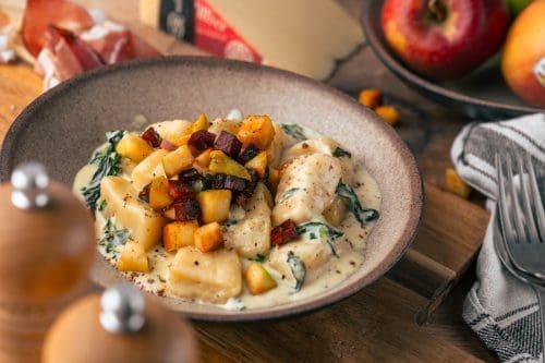 Rezept für selbstgemachte Gnocchi in einer cremigen Käsesauce mit Apfel-Speck-Crunch. Das Highlight sind die leckeren Südtiroler Spezialitäten mit Gütesiegel!