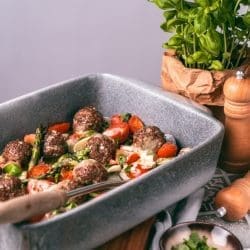 Ofenhackbällchen in der Auflaufform mit Kräutern