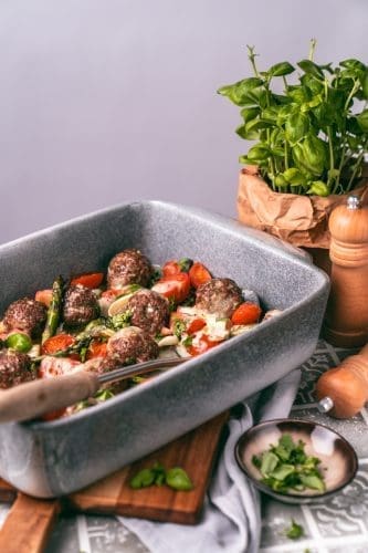 Ofenhackbällchen in der Auflaufform mit Kräutern