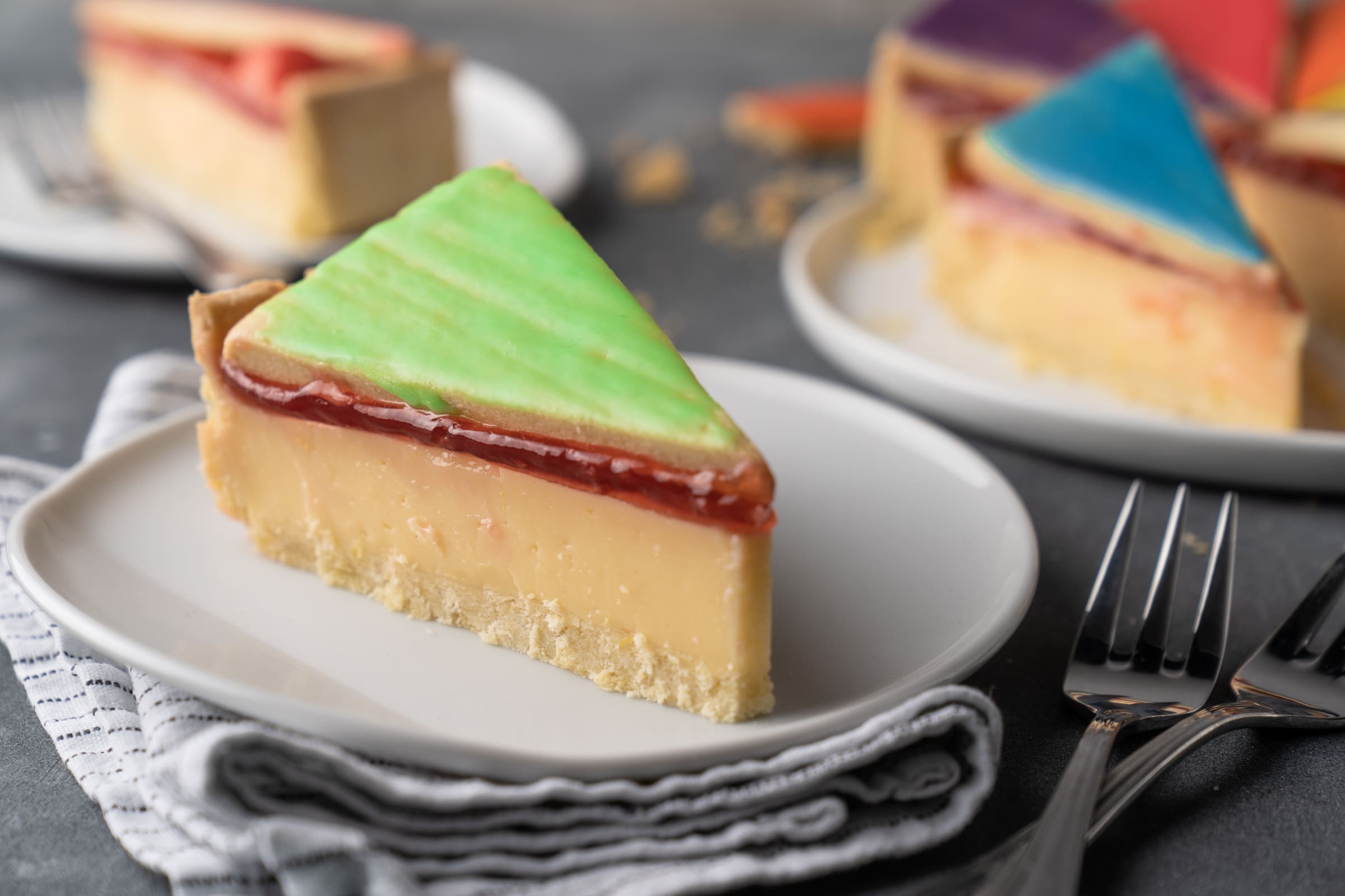 Rezept für eine Zitronentorte. Mürbeteig, eine zitronige Puddingcreme und als Topping ein Wild Berry-Guss! Da i-Tüpfelchen sind die Keksdeckel im Regenbogendesign.