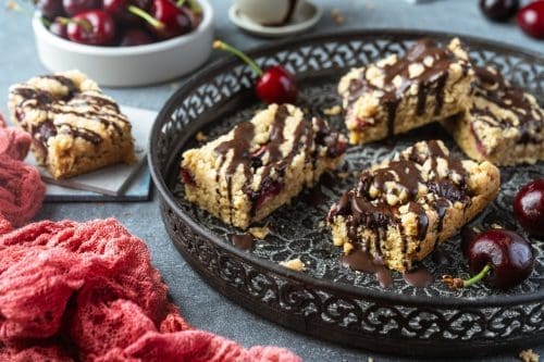 Der perfekte Snack. Sowohl nahrhaft als auch köstlich, diese Haferriegel schmecken wie Streuselteig und haben frische Kirschen als köstliches Highlight.