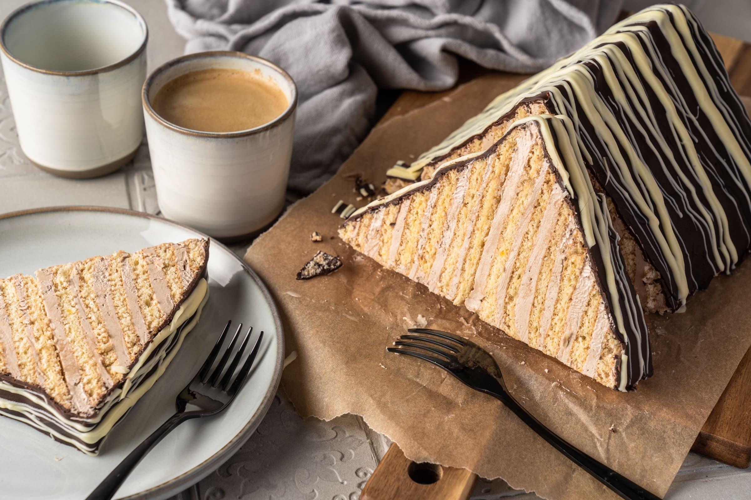 Margarethenschnitt Pyramidenkuchen 13 | Es ist kein Geheimnis, dass ich ein Foodie bin, und wenn Du das auch bist, dann ist dieser Blogbeitrag genau das Richtige für Dich. Eine meiner liebsten Kindheitserinnerungen ist die Zeit, in der meine Mama eine Margarethen-Schnitte aus der Konditorei, in der sie gearbeitet hat, mitgebracht hat. Mir läuft das Wasser im Mund zusammen, wenn ich nur daran denke! Der Kuchen in Dreieckform  aus meiner Kindheit war im Grunde eine leckere Nougattorte: Schicht um Schicht aus dünnem Biskuit im Wechsel mit einer Nougat-Buttercreme. Was soll ich sagen? Wenn es Margarthen-Schnitte gab, hab ich jeden anderen Kuchen stehen lassen. Worauf wartest du also noch? Legt eure Backutensilien bereit, nehmt Eier, Mehl, Butter und Zucker und macht euch daran, Saschas Margarethen-Schnitte zu backen!