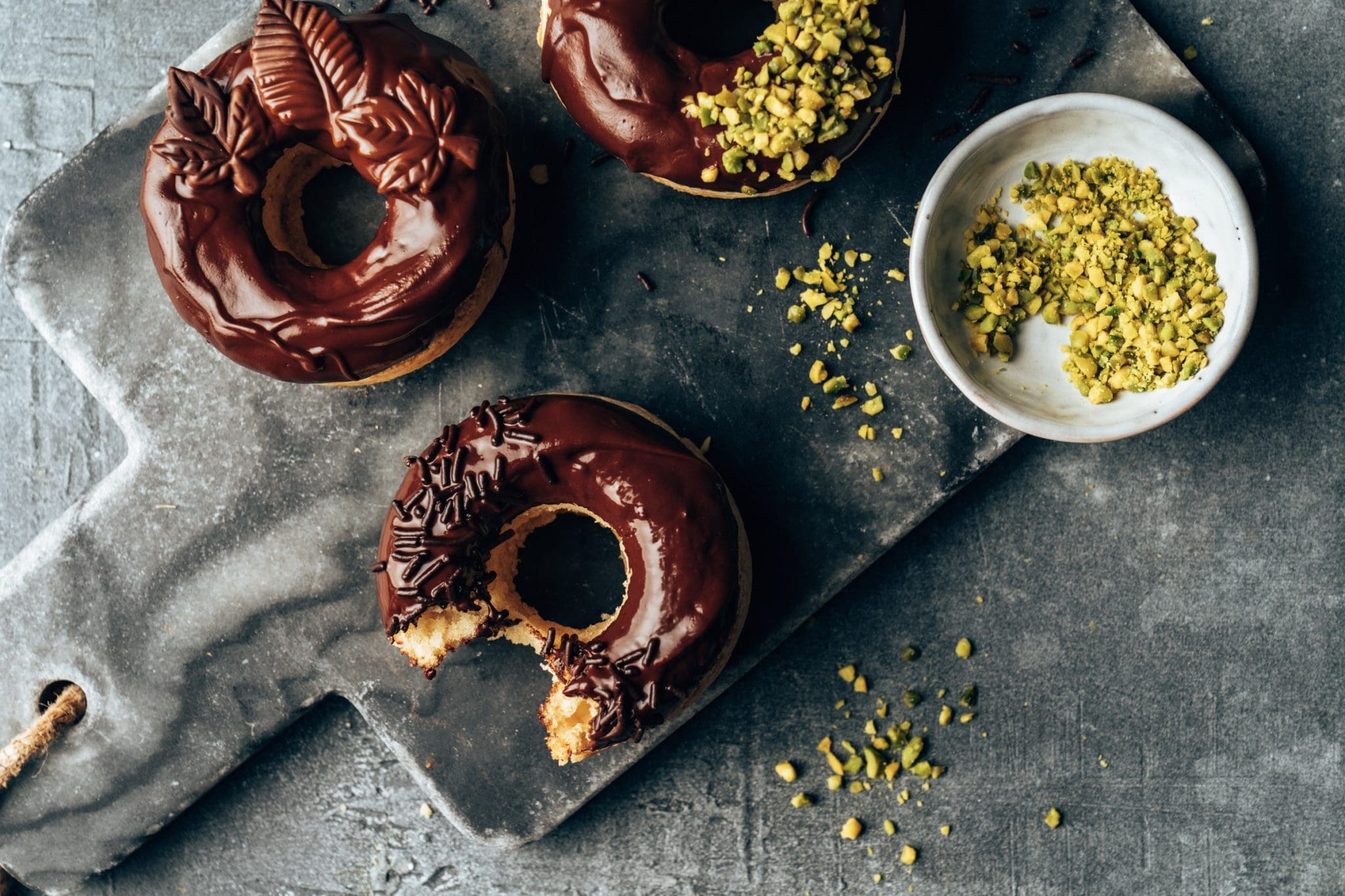 Vegane Schoko Donuts 18 | Wenn es Euch so geht wie uns, sind die einzigen veganen Donuts, die Ihr bisher kanntet, trocken und geschmacklos. Daher mussten wir uns einfach an einem eigenen veganen Rezept für saftige Donuts austesten! Wir probieren ja  ständig neue Rezepte aus und entdecken interessante Dinge im Supermarkt. Daher geht es heute auch um Schokoladenglasur - unsere Lieblingsglasur. Wir haben uns so richtig bei der Verzierung der veganen Donuts ausgetobt und sie waren ein solcher Erfolg, dass uns jetzt jeder nach diesem einfachen Rezept fragt.