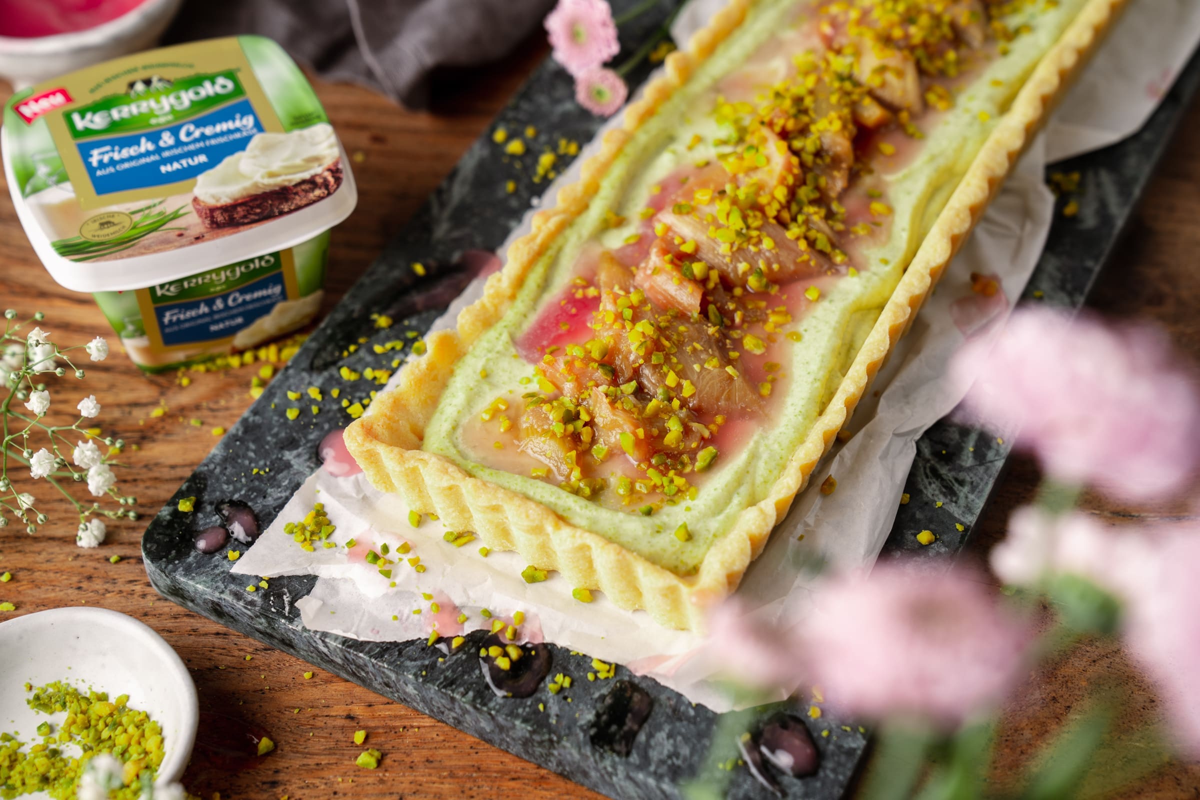 Pistazien-Tarte mit Vermouth-Rhabarber | Unser Frühlings-Cheesecake 2 Pistazientarte rhabarber 15 | Die Rhabarbersaison ist in vollem Gang und wir können einfach nicht aufhören, uns Gedanken über neue Rezepte zu machen. Da ist das völlig egal, ob gebacken oder gekocht wird. Wir stehen einfach auf dieses saure Knöterichgewächs und freuen uns immer wieder das ganze Jahr über. Für unser neuestes Rhabarber-Rezept haben wir unseren Frischkäseliebling, den neuen Kerrygold "Frisch & Cremig natur" als Hauptdarsteller eingeplant. Und herausgekommen ist unsere Pistazien-Tarte mit Vermouth-Rhabarber. Die perfekte Frühlingstarte - sieht nicht nur mega aus, schmeckt auch so! Ein echtes Aromenfeuerwerk auf dem Kuchenteller ...
