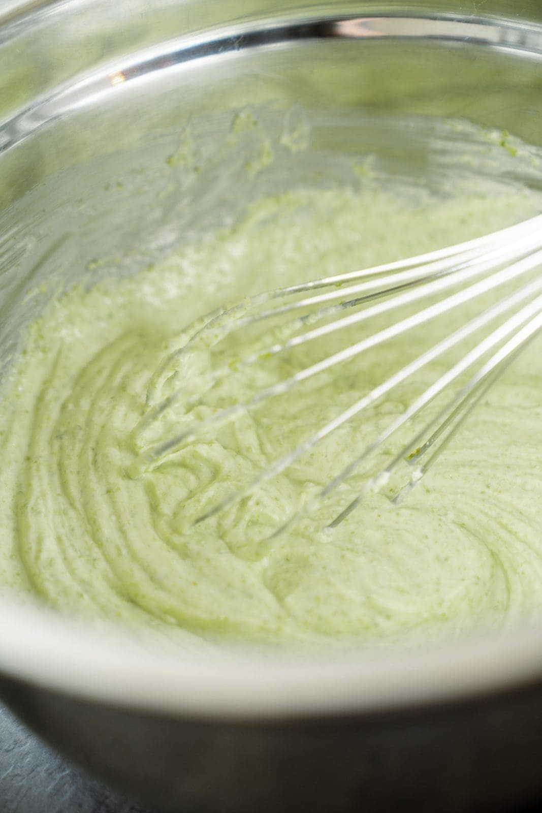Pistazien-Creme wird mit einem Schneebesen in einer Schüssel angerührt.
