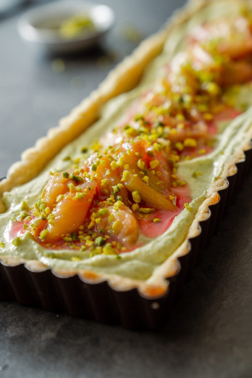Fertige Pistazien-Tarte mit Rhabarber bedeckt