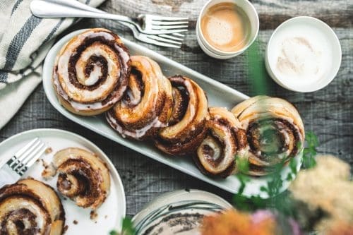 Zimtschnecken 20 | Gerade beim Schreiben unseres neuen Rezeptes sitze ich noch in unserem tollen Farmhaus in Dänemark. Und nebenbei backen im Ofen unsere Zimtschnecken, die wir Euch unbedingt zeigen müssen, damit Ihr sie nachbacken könnt. Ihr glaubt gar nicht, wie krass das ganze Haus nach Zimt riecht. Ich liebe den Geruch und kann kaum die Finger vom Ofen lassen und immer wieder nachschauen, ob sie vielleicht doch schon fertig sind, damit ich sie probieren kann. Normalerweise ist Sascha ja der Ungeduldige von uns beiden, aber bei süßen Schnecken aller Art kann ich mich auch nicht zurückhalten.