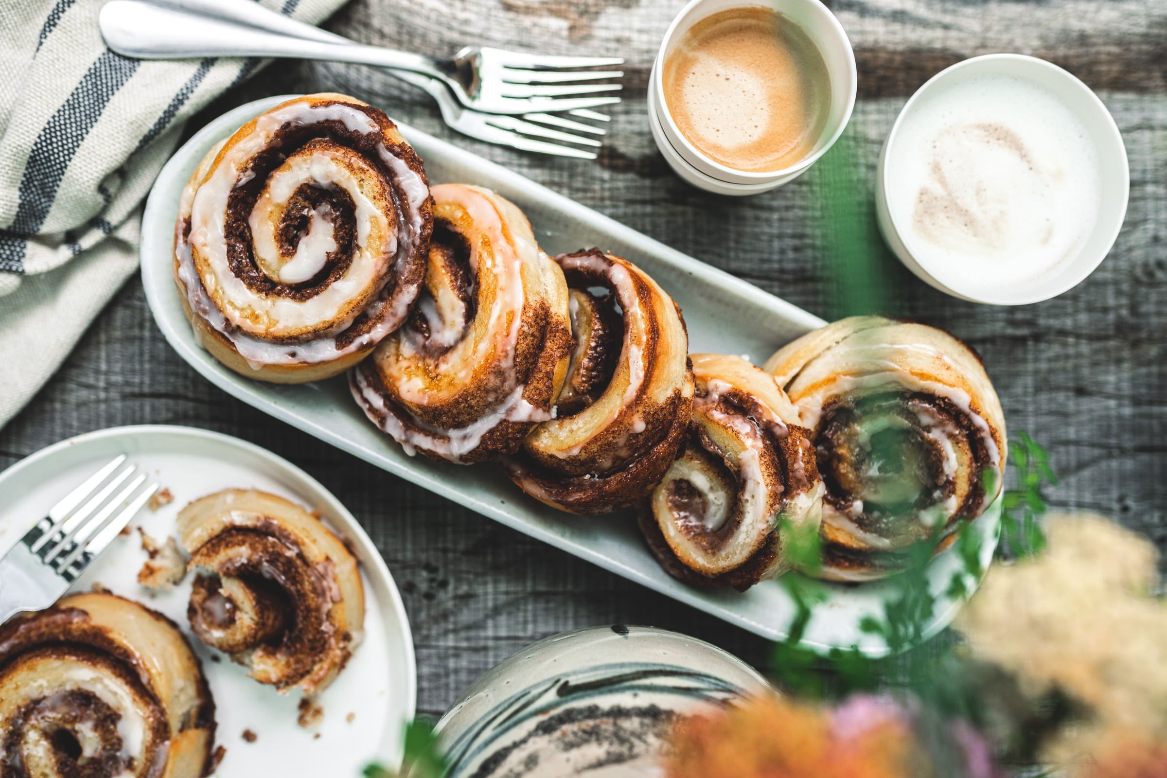 Zimtschnecken 20 | Gerade beim Schreiben unseres neuen Rezeptes sitze ich noch in unserem tollen Farmhaus in Dänemark. Und nebenbei backen im Ofen unsere Zimtschnecken, die wir Euch unbedingt zeigen müssen, damit Ihr sie nachbacken könnt. Ihr glaubt gar nicht, wie krass das ganze Haus nach Zimt riecht. Ich liebe den Geruch und kann kaum die Finger vom Ofen lassen und immer wieder nachschauen, ob sie vielleicht doch schon fertig sind, damit ich sie probieren kann. Normalerweise ist Sascha ja der Ungeduldige von uns beiden, aber bei süßen Schnecken aller Art kann ich mich auch nicht zurückhalten.