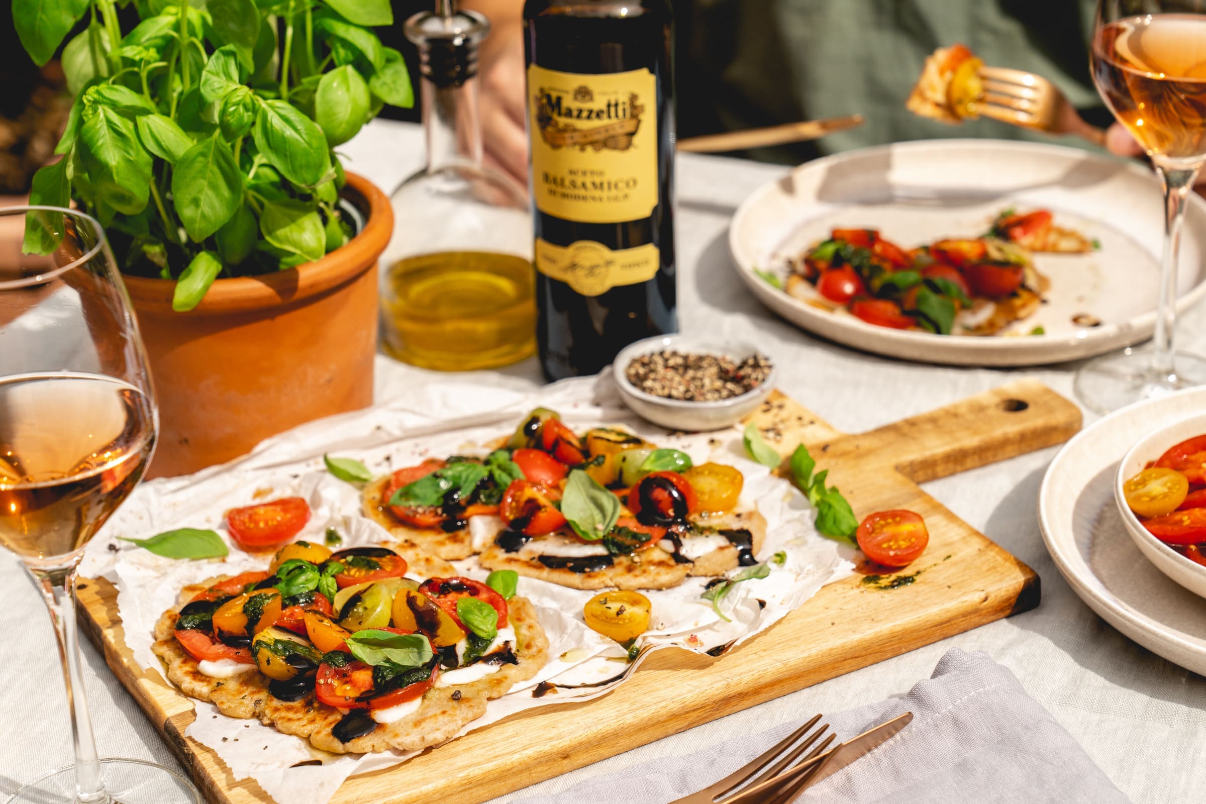 Caprese Flatbread Mazzetti 32 | Die Tomatenernte in den Gärten unserer Eltern lässt einfach nicht nach. Das ist natürlich gut so - heißt aber auch, sie müssen sich immer etwas Neues einfallen lassen, um nicht jeden Tag einen ganz normalen Tomatensalat zu essen. Den mögen wir alle sehr gerne, denn gerade mit frisch geernteten Tomate ist der nochmal so lecker. Aber trotzdem ist ein wenig Abwechslung immer gut. Und da wir beide uns gerade wieder ein schönes Rezept für unseren Partner Mazzetti L'Originale aus Modena überlegen durften, haben wir gleich an eine tolle Caprese Variante gedacht und sie auch direkt mal für unsere Eltern ausprobiert. Herausgekommen ist dieses Caprese Flatbread, bei dem der gute Balsamico eine wichtige Rolle spielt. Schnell zubereitet und unglaublich lecker - überzeugt Euch selbst!