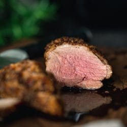 Knusprige Entenbrust aus der Heißluftfritteuse. Aufgeschnitten auf dem Brett. Rosa glänzendes Brustfleisch.