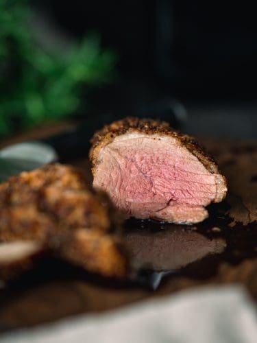Knusprige Entenbrust aus der Heißluftfritteuse. Aufgeschnitten auf dem Brett. Rosa glänzendes Brustfleisch.
