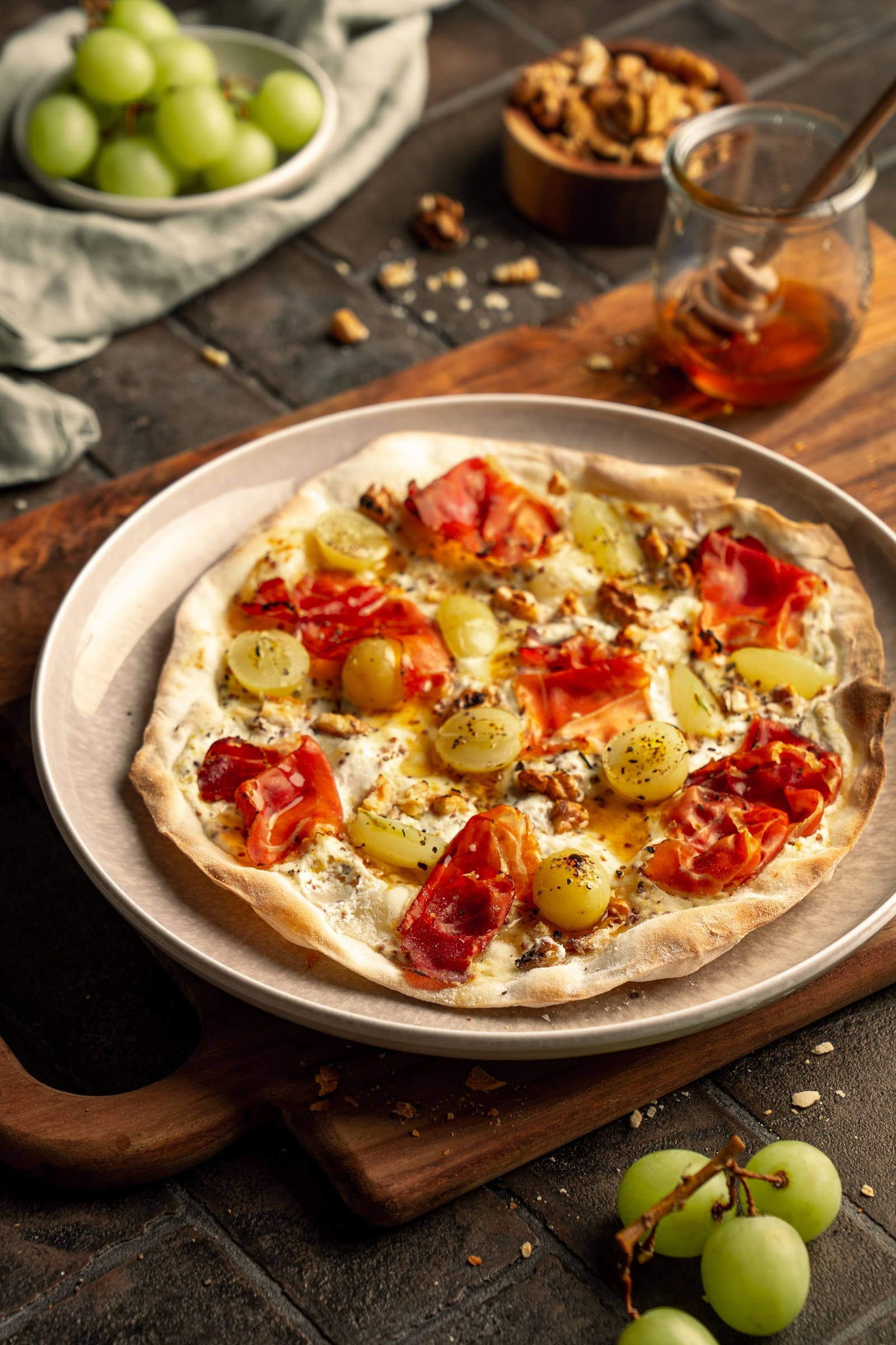 Winzer Flammkuchen VB 6 | Dieses Rezept hier ist für mich in vieler Hinsicht ein ganz besonderes. Es ist ein Stück Hommage an meine Heimat. Wir haben es kreiert für einen besonderen Partner und ein besonderes Ereignis. Denn nur 30 km von meinem Heimatort entfernt, haben wir für Villeroy & Boch und eine liebe Gruppe an ausgewählten Gästen einen kleinen Kochkurs in ihrem neuen traumhaften Küchenstudio "La Cuisine" gegeben. Dieser Winzer-Flammkuchen mit Trauben, Schinken & Walnüssen war eines der Gerichte, das wir gemeinsam mit allen gekocht haben. Schnell gemacht, eine Aromenbombe und unwiderstehlich lecker.