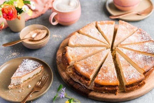 Käsekuchen mit karamellisiertem Rhabarber. Kaffee im Hintergrund.