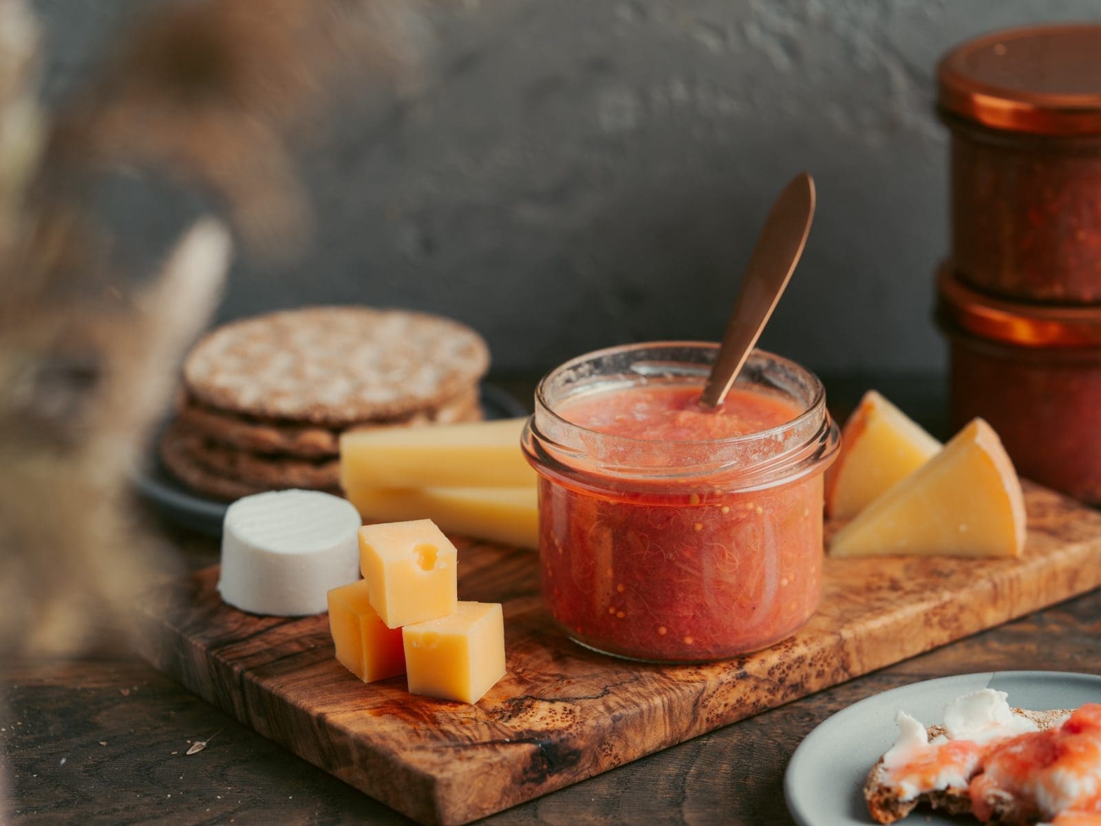 Rhabarber Chutney selber machen - würzig, fruchtig, schnell im Glas 8 Rhabarber-Chutney im Glas auf dem Brett dekoriert mit Käse und Gebäck