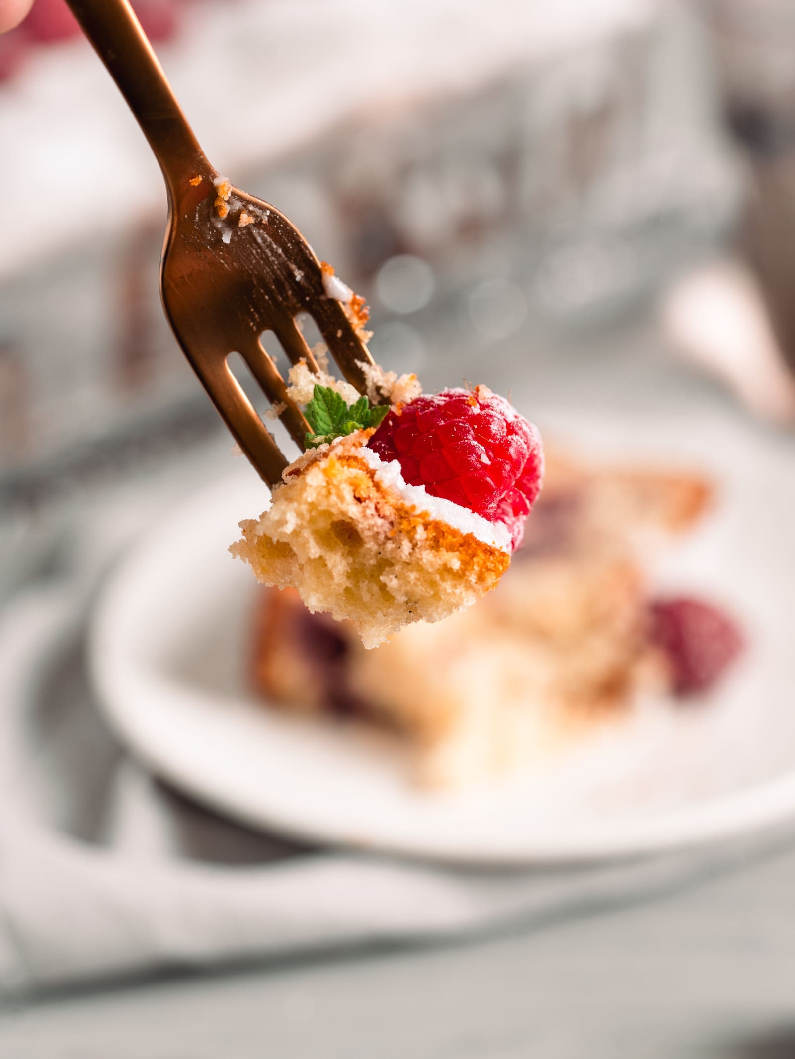 Gabel mit einem Bissen Joghurt-Himbeerkuchen und Himbeere