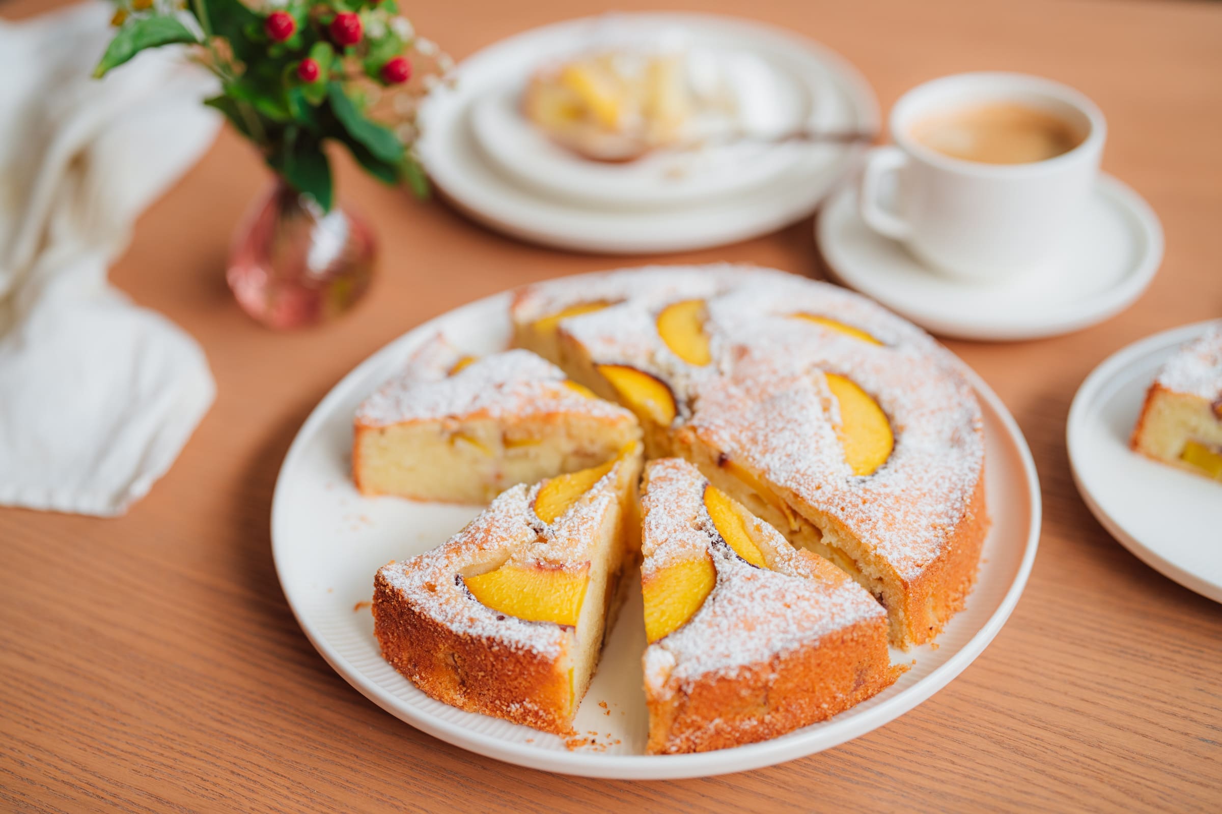 Pfirsischkuchen 5 | Wir sind so froh, euch in diesem Jahr noch mit einem neuen Pfirsich-Rezept überraschen zu können. Saftiger Pfirsichkuchen mit Tonkabohne ist uns ganz spontan eingefallen. Eigentlich haben wir als Basis des Rührteiges einen alten Klassiker von Oma Lore eingesetzt und ein wenig verfeinert. Saurer Sahne und etwas Tonkabohne hat schon gereicht um Omas Rührkuchen noch saftiger mit dem besonderen Aroma zu machen. Lea war so lieb und hat mich videografisch bei der Umsetzung des Rezeptes und Sascha beim Shooting tatkräftig unterstützt. Habt ihr in dieser Pfirsich-Saison auch schon einen Kuchen mit dem leckeren Obst gebacken? Dann sollet ihr nun ganz fix ran.