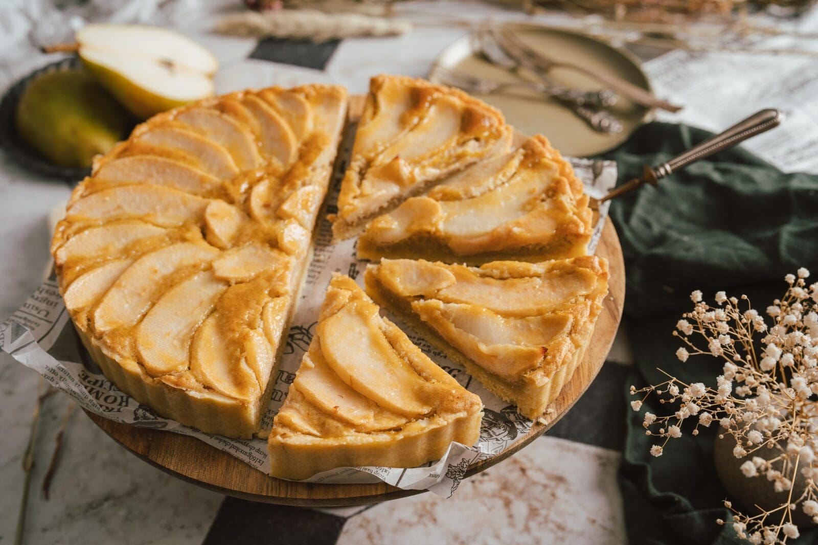 Birnen Haselnuss Tarte 3 | Wir geben es zu: Gebackene Birnen stehen bei uns nicht ganz oben auf der Favoritenliste. Aber zum Glück haben wir im vergangenen Jahr eine Birnen-Haselnuss-Tarte in einer Konditorei ausprobiert – und waren sofort hin und weg! Die Kombination aus süßen, saftigen Birnen, knusprigem Mürbeteig und nussiger Haselnuss-Frangipane hat uns so begeistert, dass wir unser eigenes Rezept entwickelt haben. Und was sollen wir sagen? Diese Birnen-Haselnuss-Tarte ist einfach genau das Richtige für die Kaffeetafel am Sonntag! Oder auch einfach nur so zwischendurch. Wenn ihr also Lust auf eine Tarte habt, die perfekt abgestimmt ist, dann probiert unsere Birnen-Haselnuss-Tarte unbedingt aus.