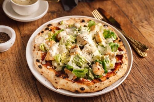 Caesar Salad Pizza – Zwei Klassiker neu interpretiert 5 Caesar’s Pizza ist unsere kreative Neuinterpretation des Klassikers. Knuspriger Teig, würziges Dressing & frischer Salat – probiert unser Rezept aus!