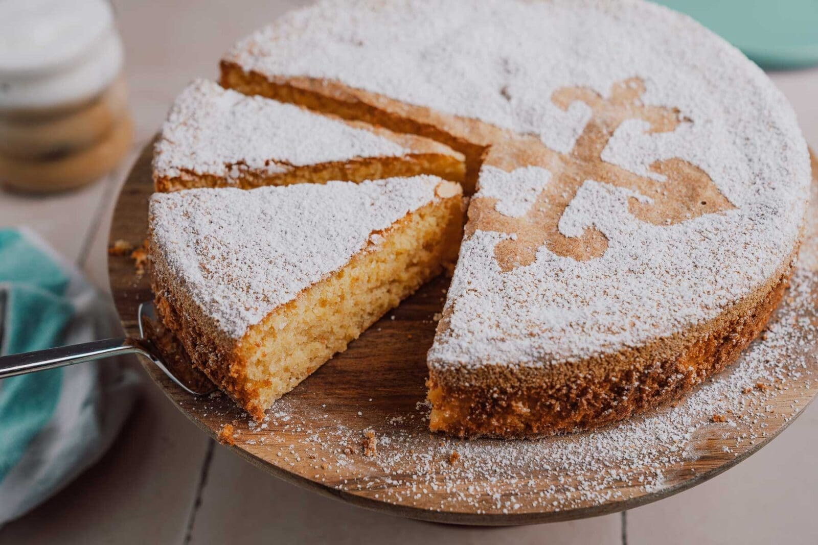 Der Anschnitt eines Stücks Tarta de Santiago, der die goldbraune Oberfläche und die mehlfreie, saftige Textur zeigt.