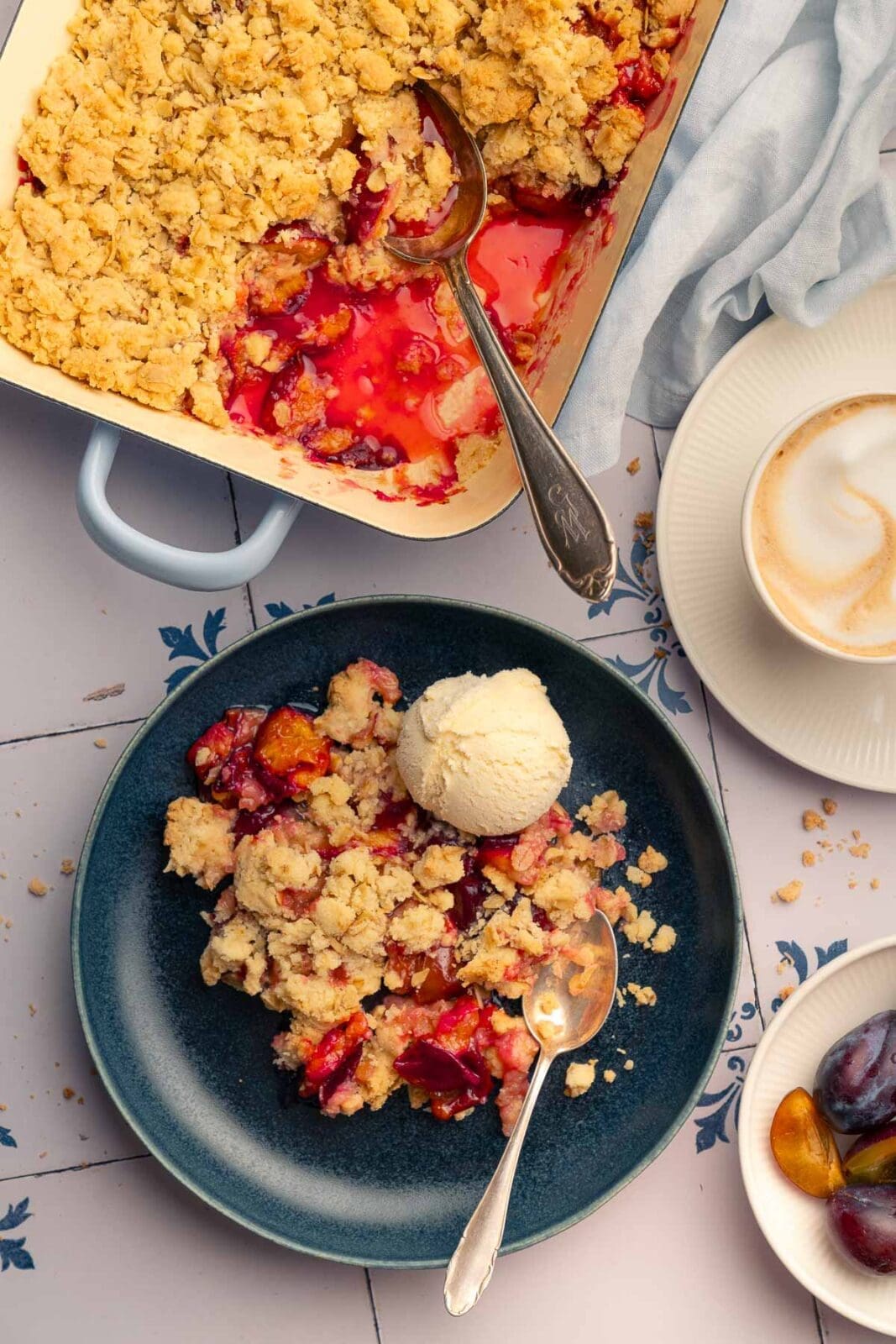 Portion Zwetschgen-Crumble mit Eis und Kaffee serviert
