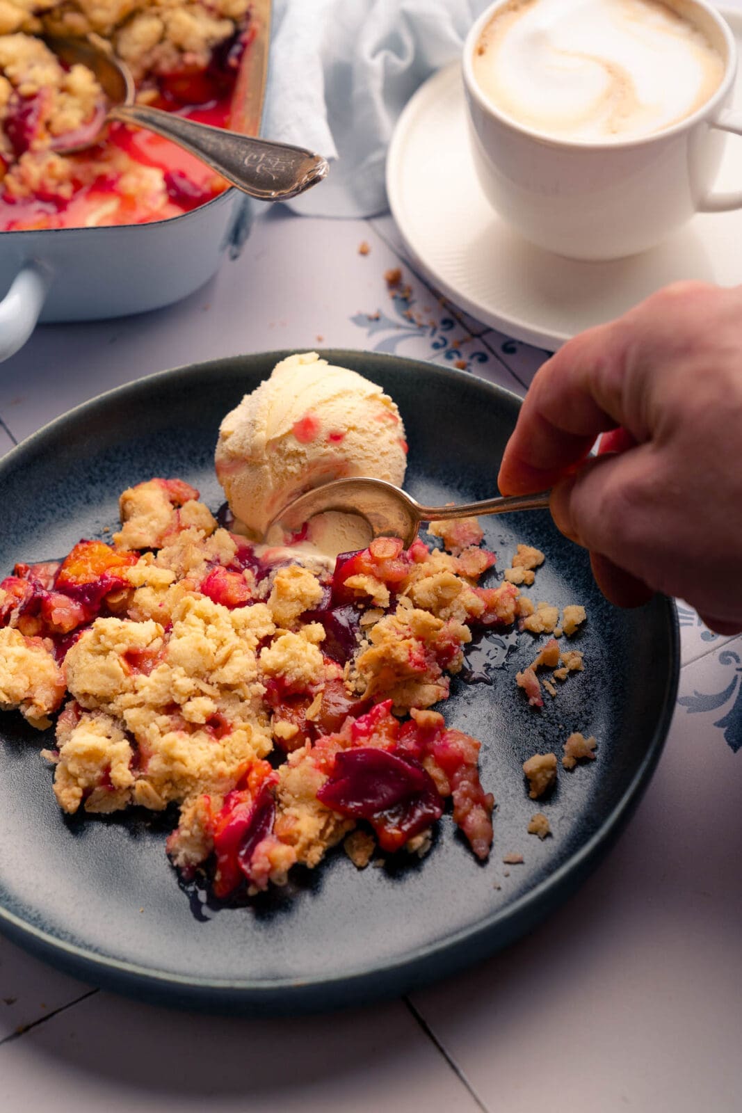 Zwetschgen-Crumble mit Eis serviert