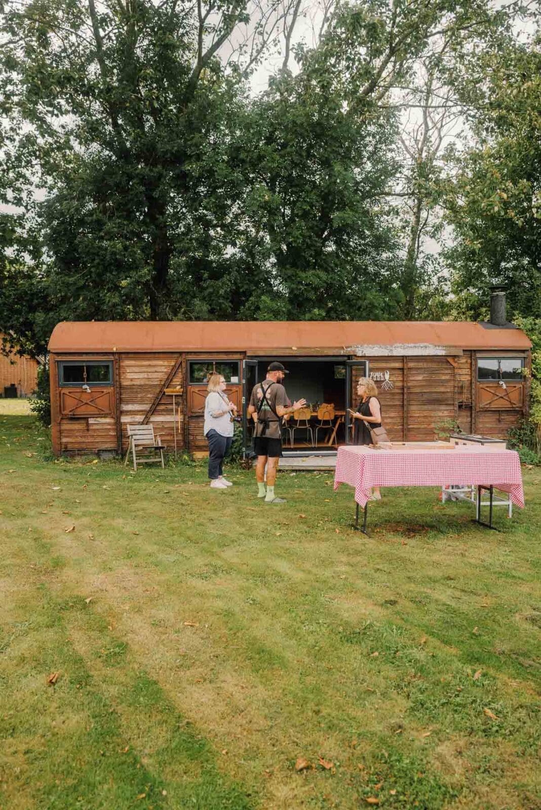 Holzhütte mit Gästen im Garten – Menschen, Orte und Geschmackserlebnisse entlang der Nordseeküste Dänemarks.