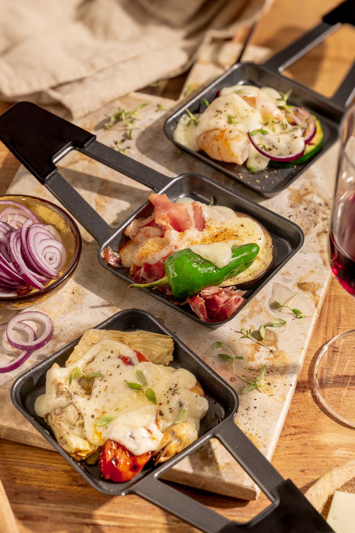 Tapas Raclette Pfännchen Ideen mit Garnelen und Zucchini, Prosciutto mit Pimientos, Artischocke und Tomate