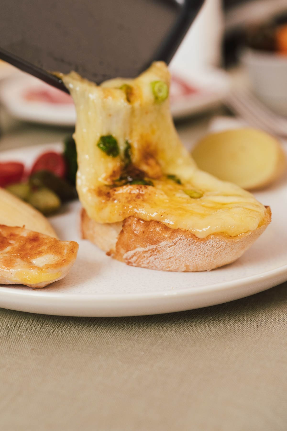 Klassisches Raclette wie in der Schweiz, geschmolzener Käse auf Brot mit Käsefäden